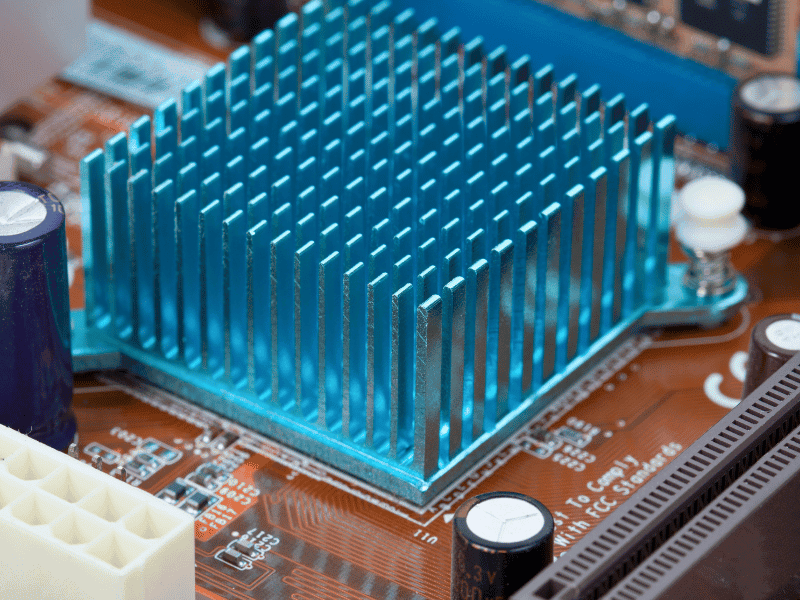 Blue anodized aluminum pin-fin heat sink on an orange PCB.