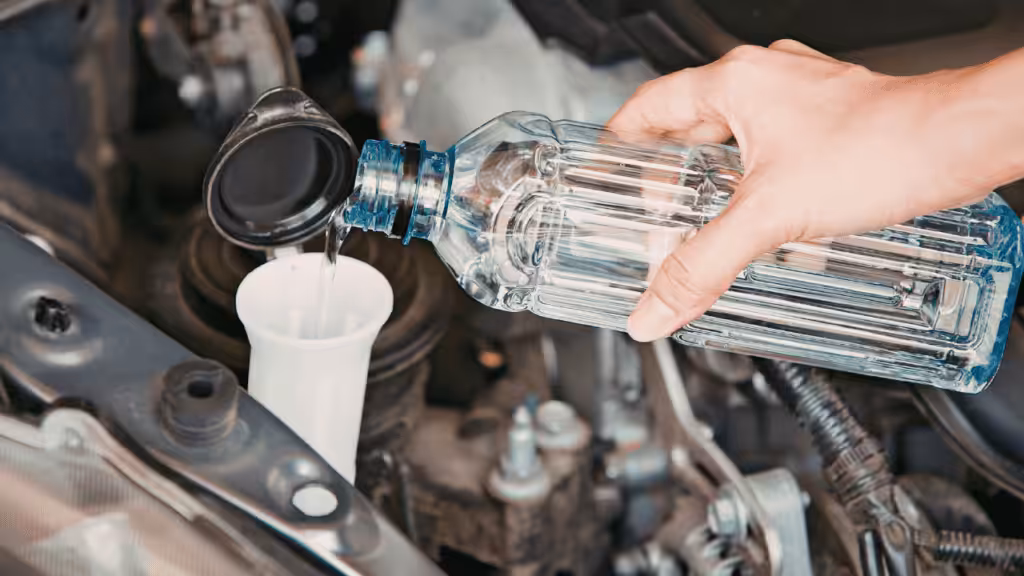 Car radiator coolant being poured during maintenance.