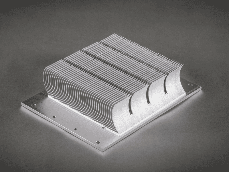 High-density silver aluminum skived fin heat sink on a dark background.