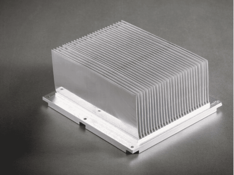 A high-density skived fin aluminum heat sink on a dark surface.